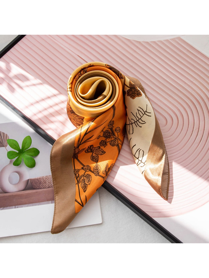 Rolled botanical scarf showing the orange, cream and brown pattern and border
