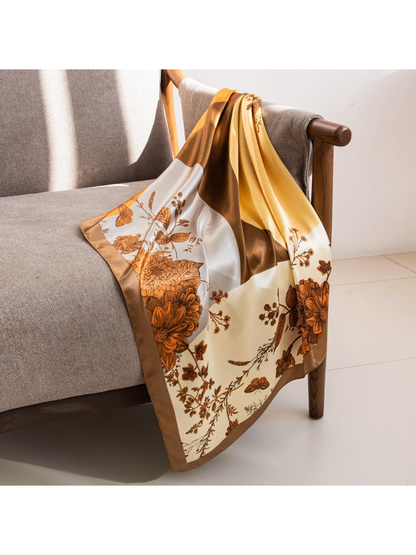 Botanical square scarf draped across a gray armchair in natural light