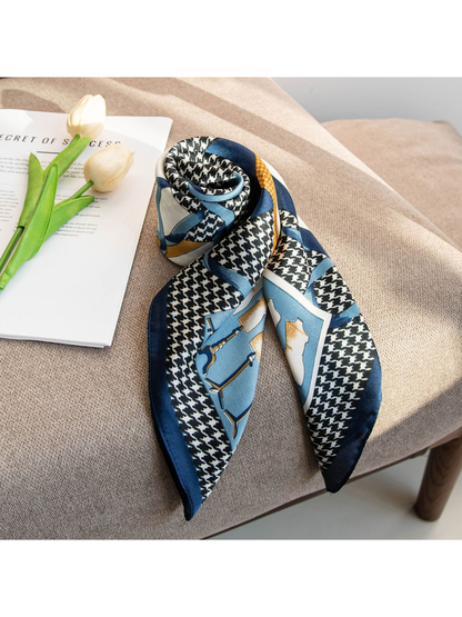 Patterned square scarf rolled and draped on a neutral chair