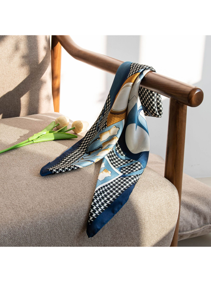 Patterned square scarf draped over a wooden chair arm in natural light
