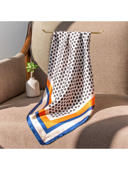 Polka-dot square scarf draped over a chair in sunlight