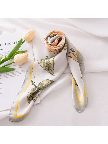 Peach rose floral scarf rolled and arranged on a white surface