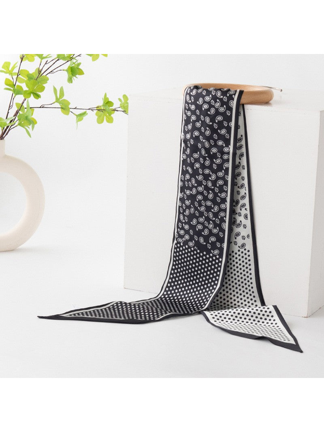 Black and white paisley and polka-dot scarf draped over a display stand