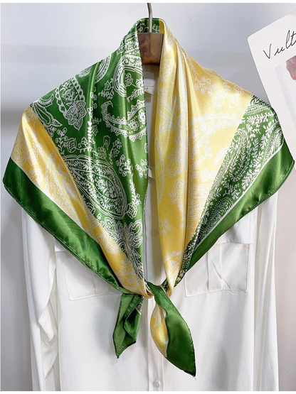Green and yellow paisley scarf tied over a white shirt on a hanger