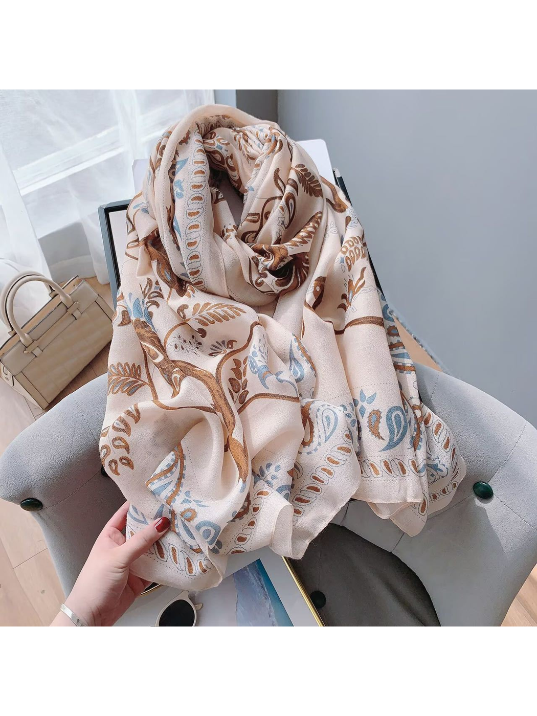 Blush paisley scarf arranged on a chair with its bird and botanical print visible