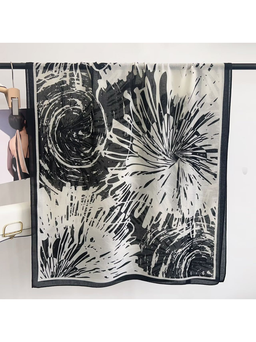 Black abstract-pattern scarf displayed open with contrasting border