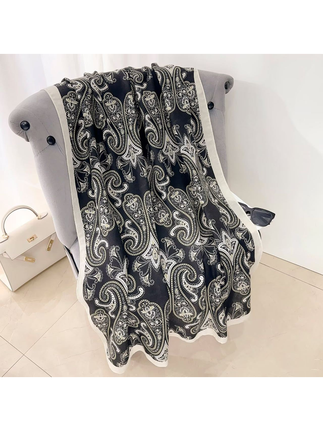 Black paisley scarf with a contrasting light border, draped view