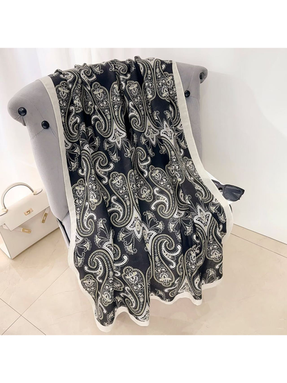 Black paisley scarf with a contrasting light border, draped view