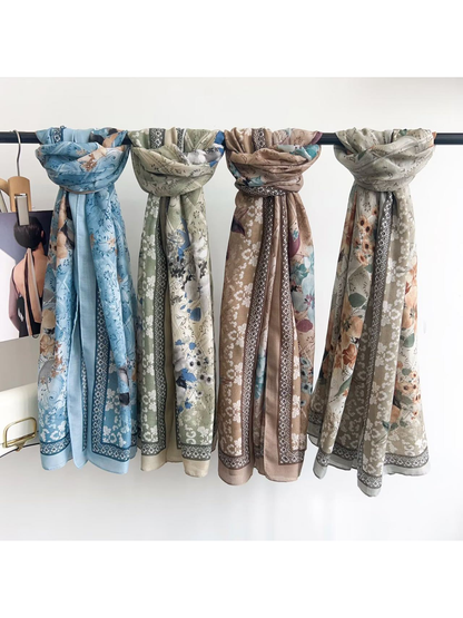 Four floral scarves in blue, green, beige and light gray displayed together