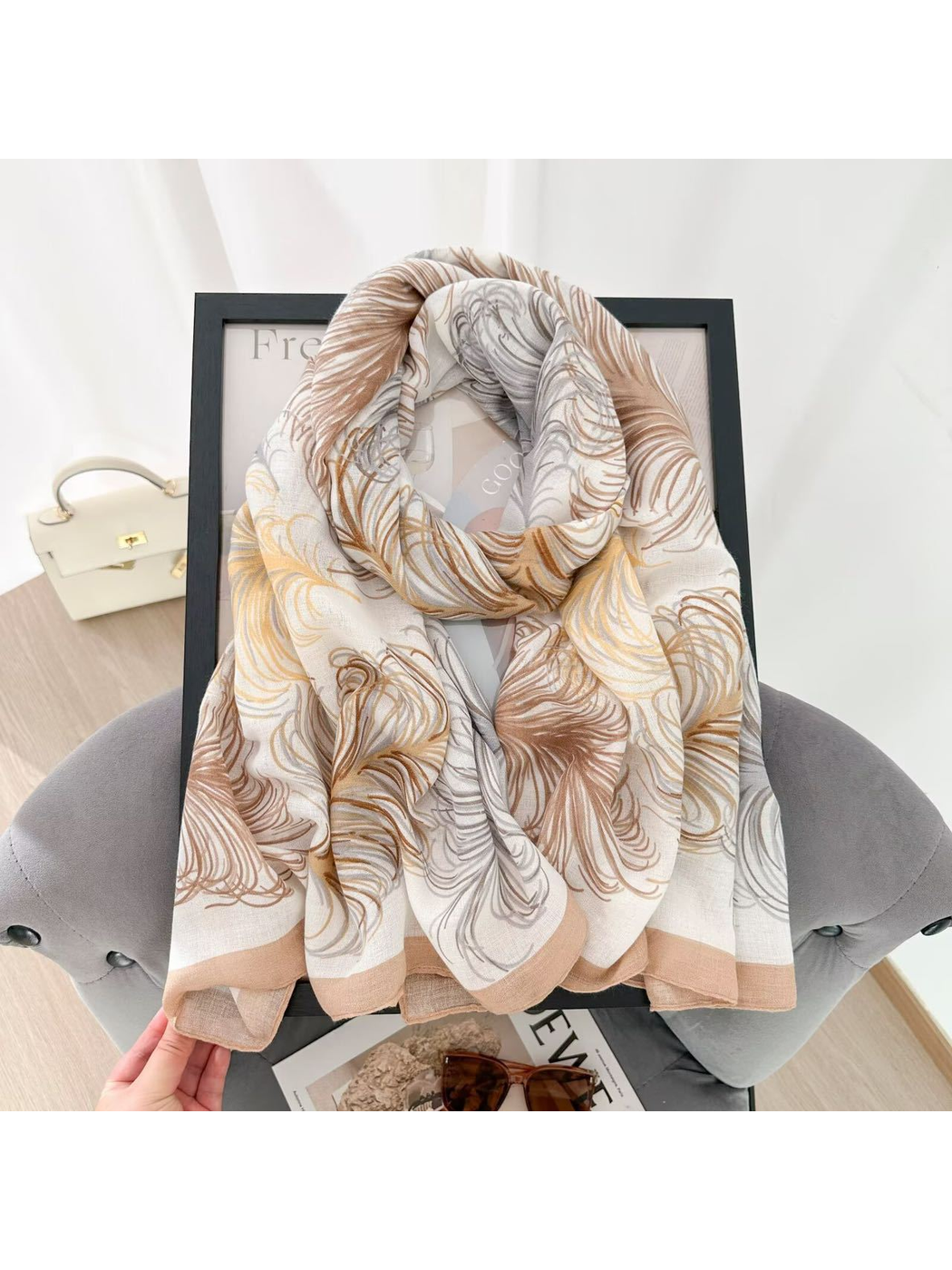 Ivory feather-pattern scarf arranged in a looped drape