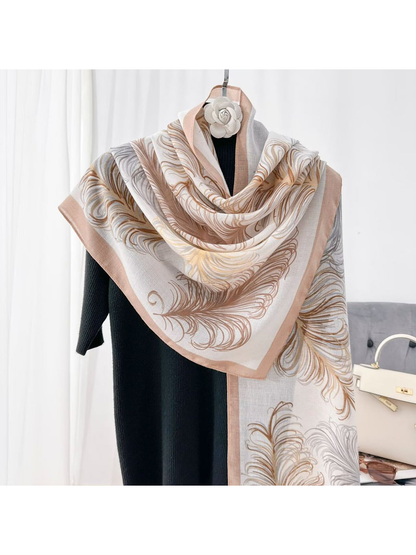 Ivory feather-pattern scarf draped over a black top