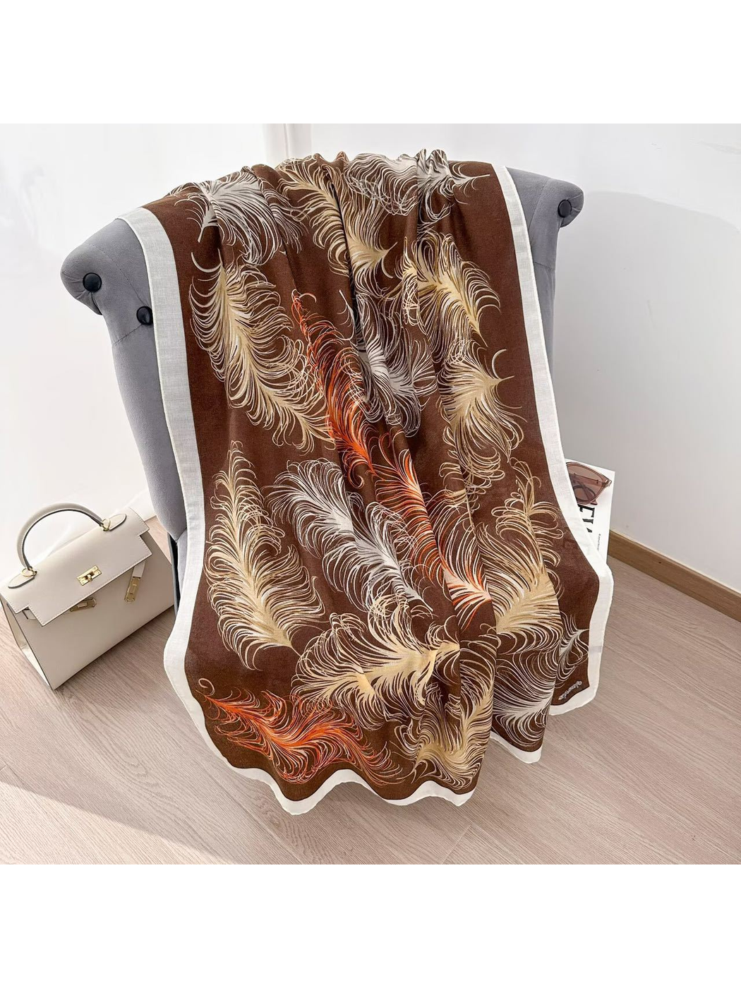 Coffee feather-pattern scarf spread over a gray chair to show the full design