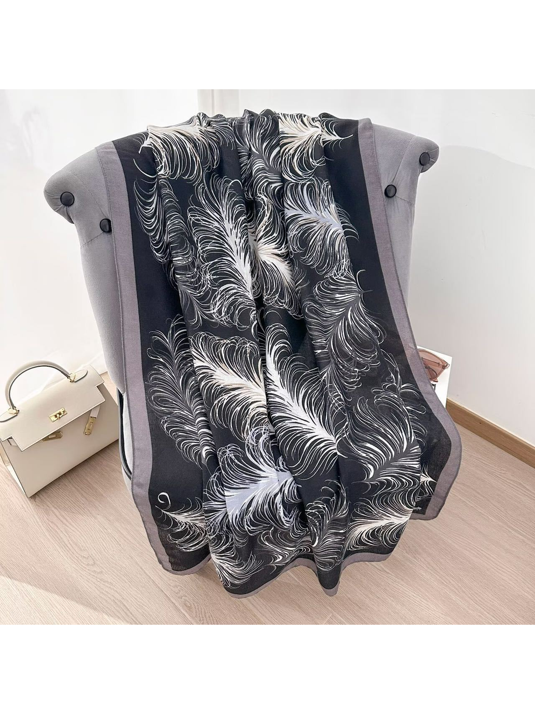Black Gray feather-pattern scarf spread over a gray chair to show the full design