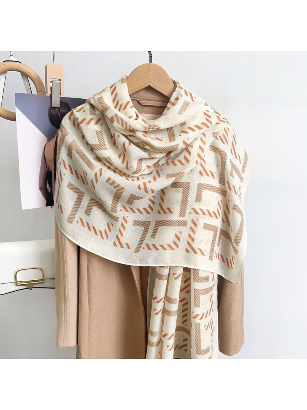 Ivory geometric scarf draped over a coat