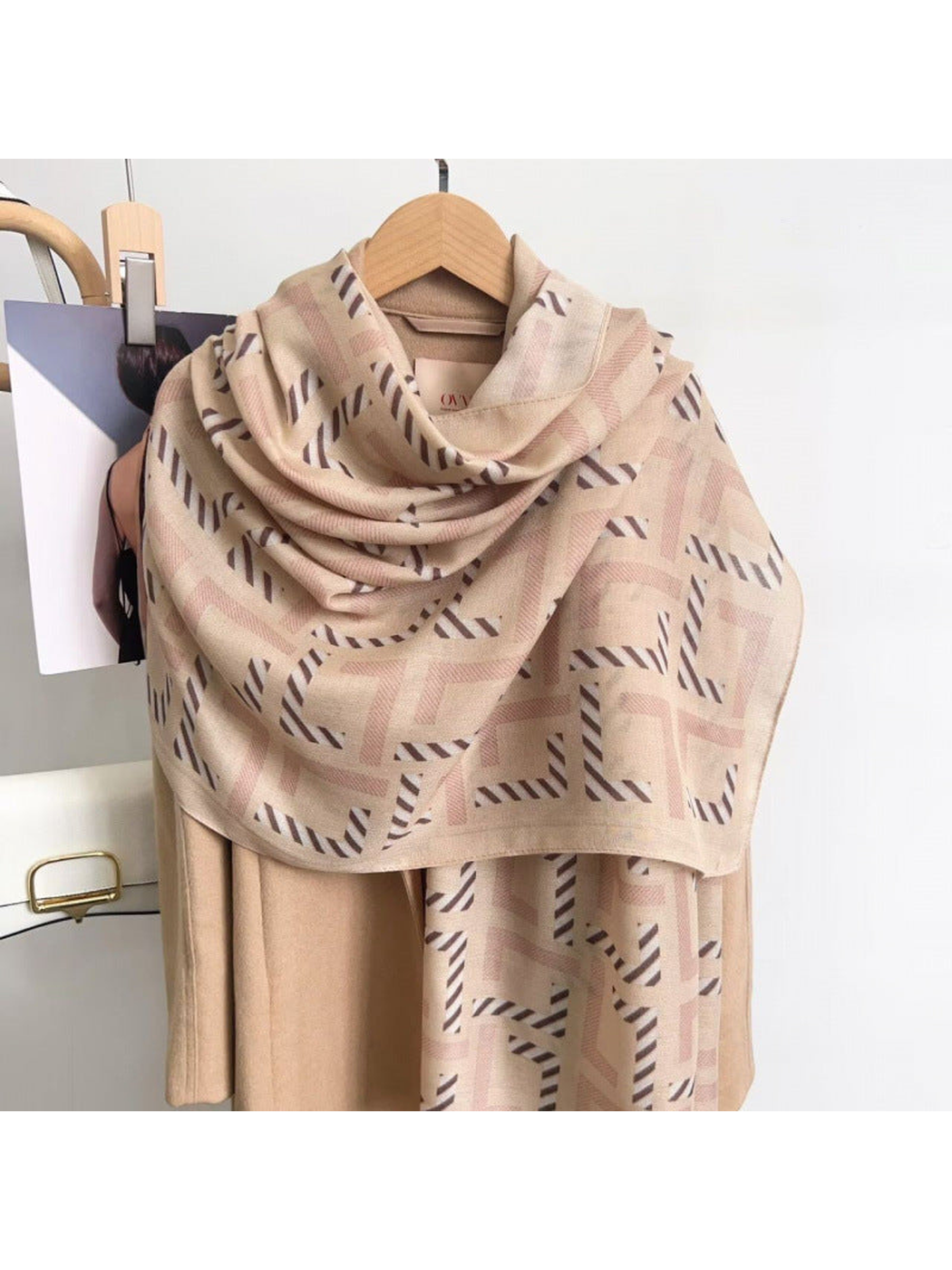 Beige geometric scarf draped over a coat