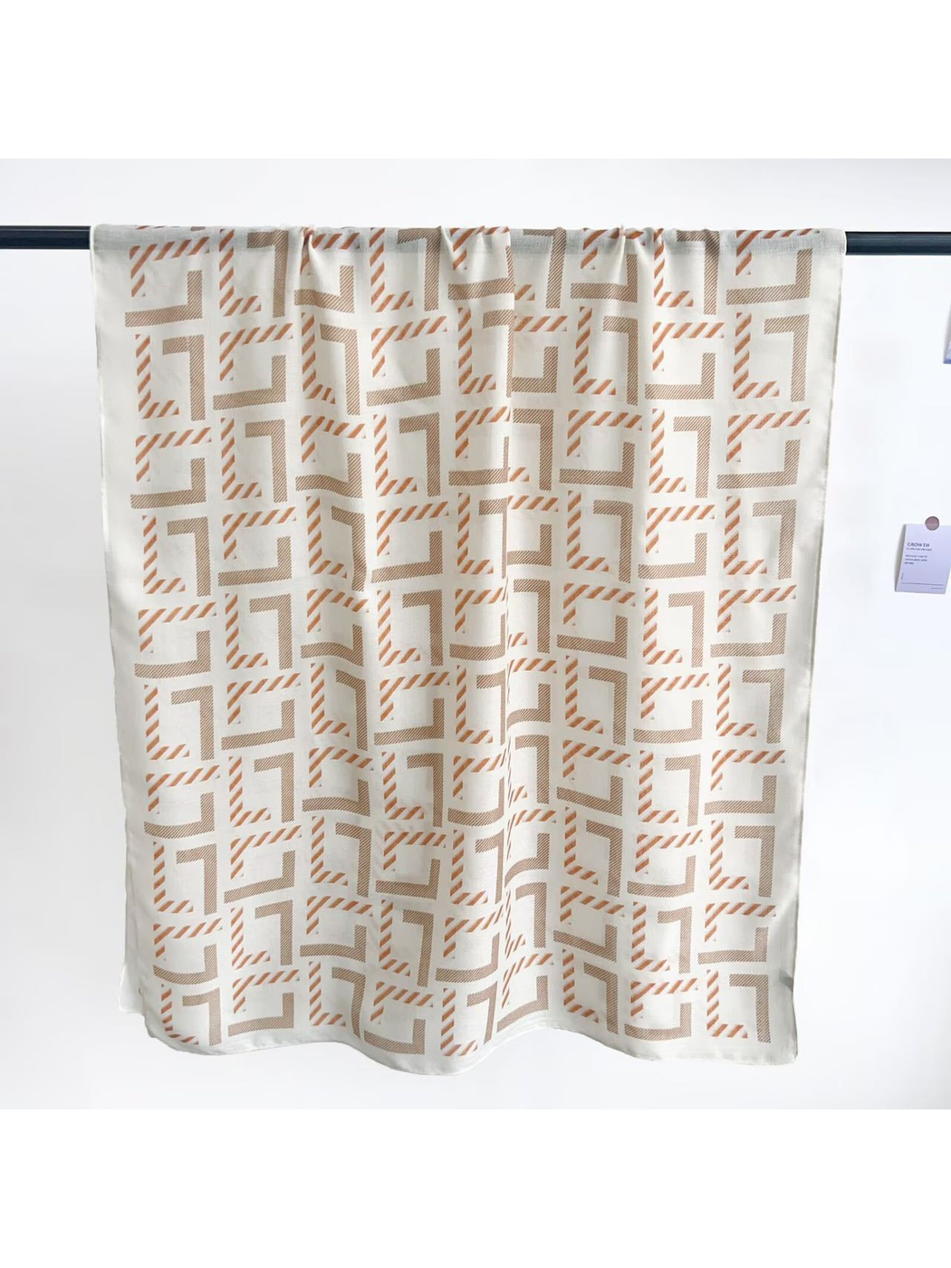 Ivory rectangular scarf displayed open to show the geometric pattern