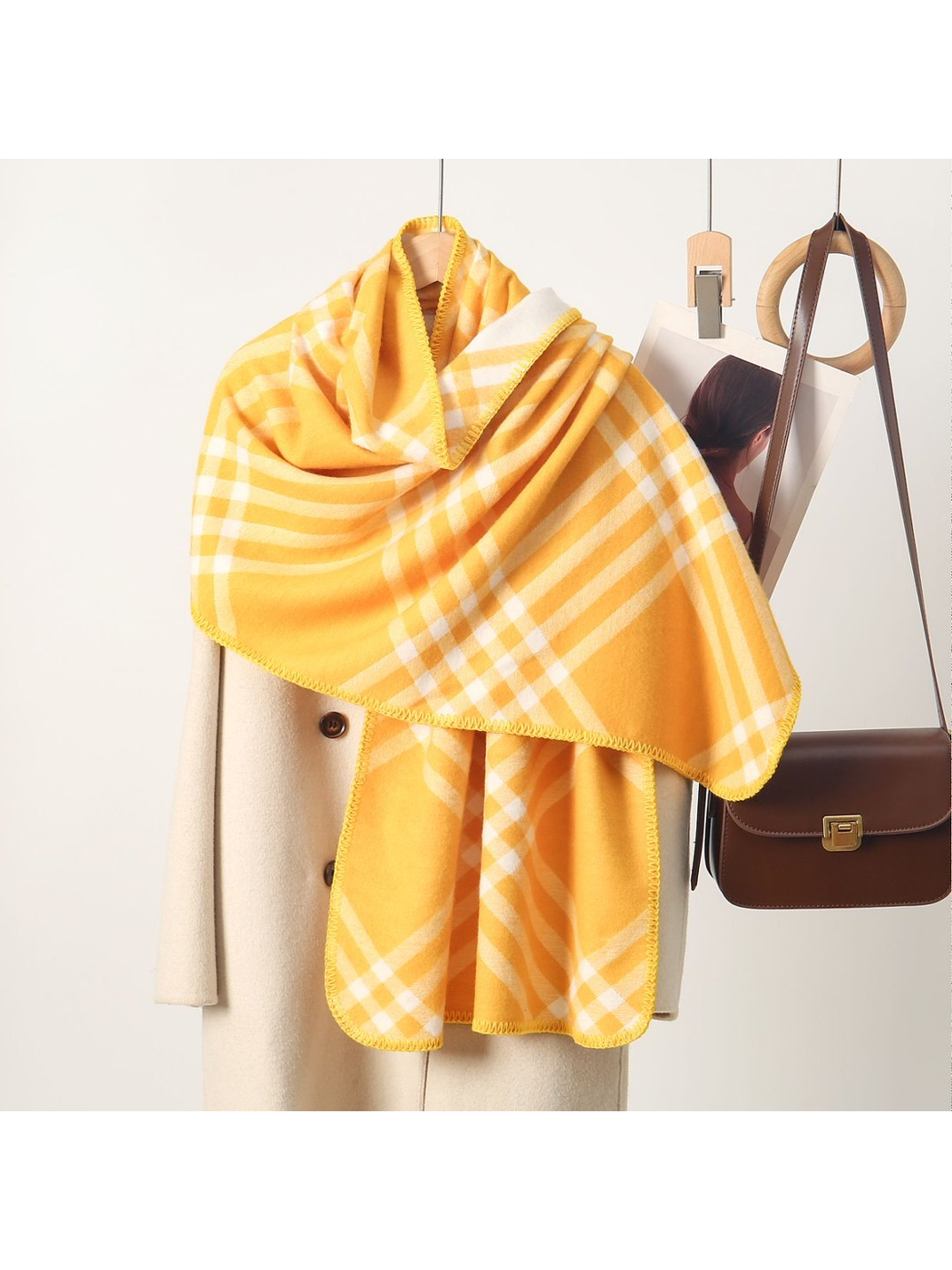 Yellow plaid rectangular scarf with stitched edges, draped display