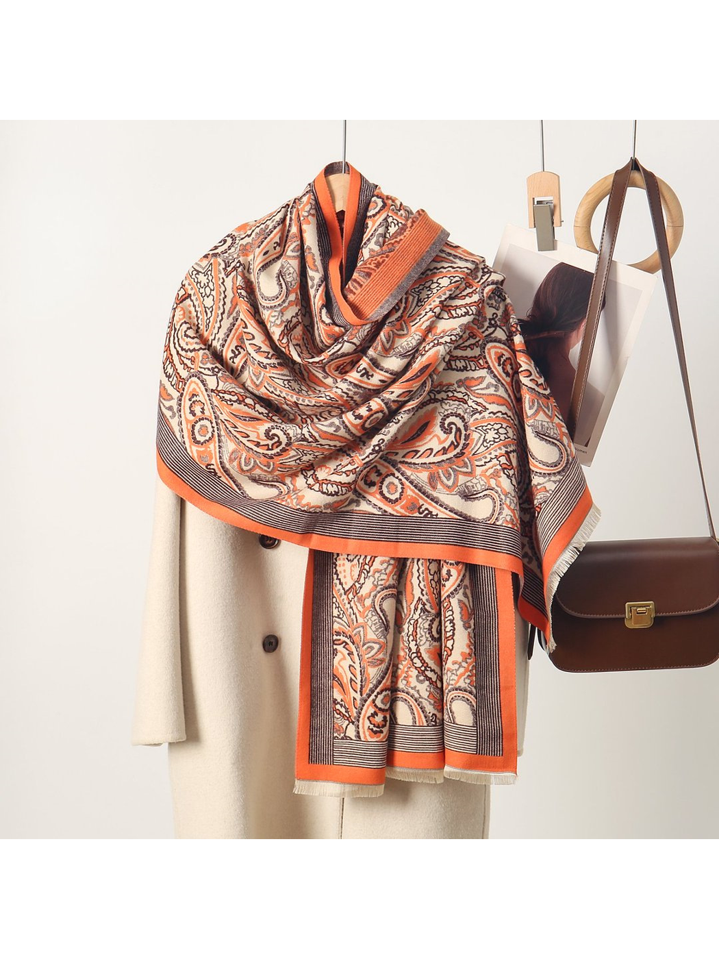 Orange paisley scarf with striped border and short fringe, draped view