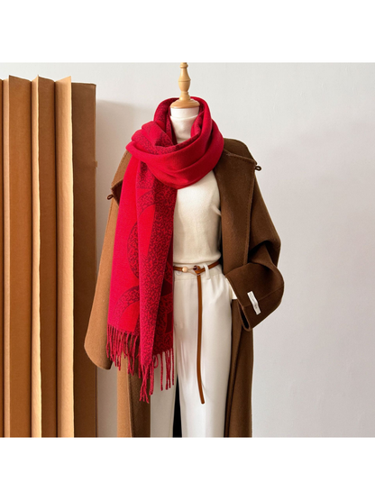 Red geometric scarf looped around a mannequin with long fringed ends