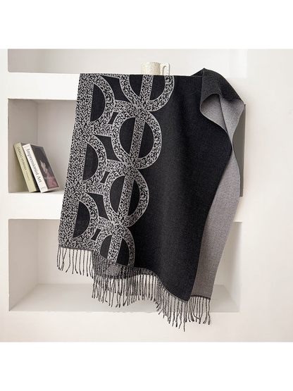 Black Gray geometric scarf draped with a contrasting reverse and fringe