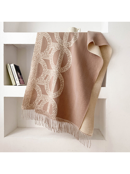 Greige geometric scarf draped with a contrasting reverse and fringe