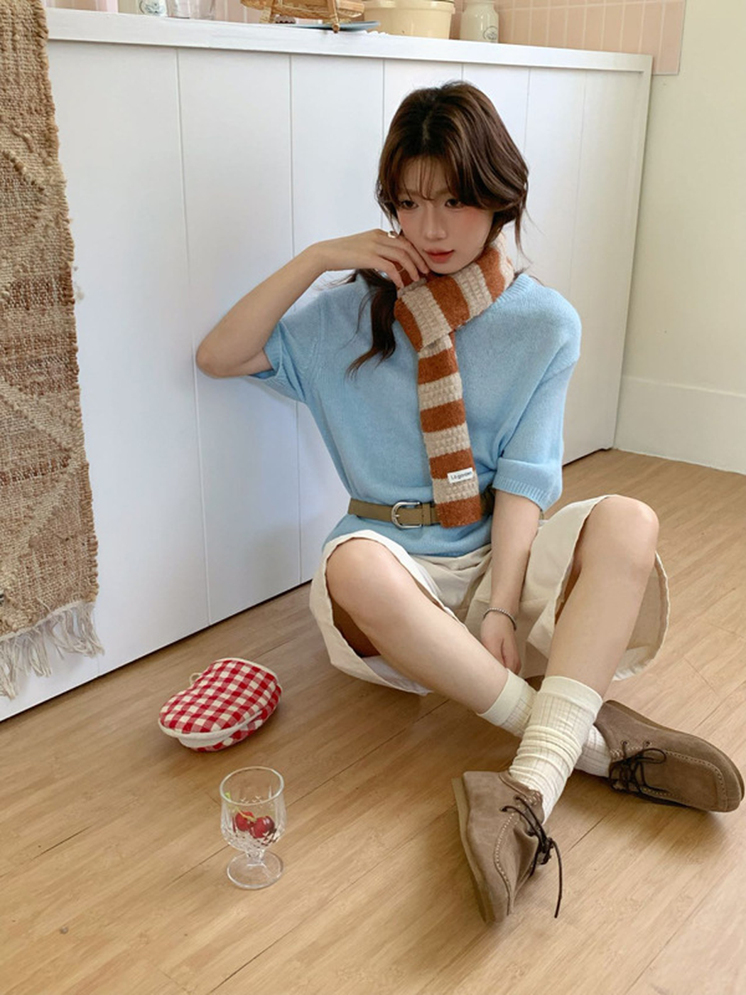 Model wearing the orange-and-cream striped scarf with a blue top
