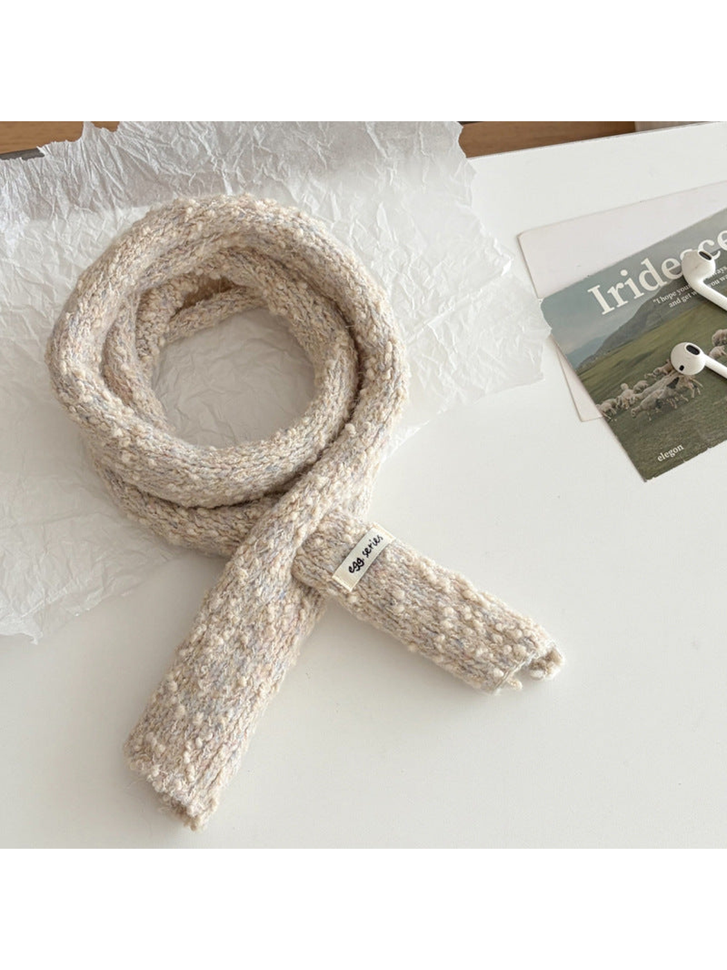 Cream narrow textured scarf arranged in a loop