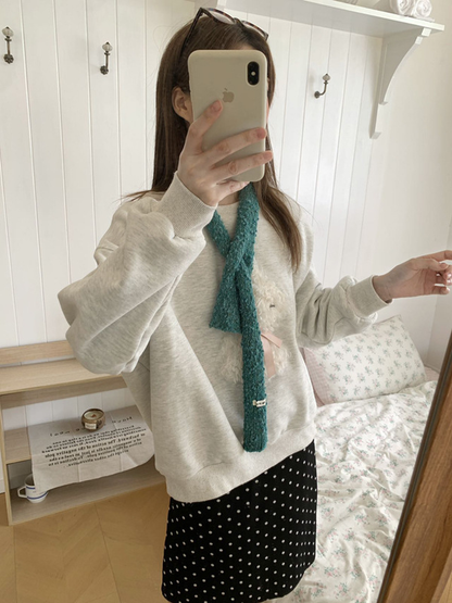 Teal Blue narrow scarf worn crossed over a gray sweatshirt