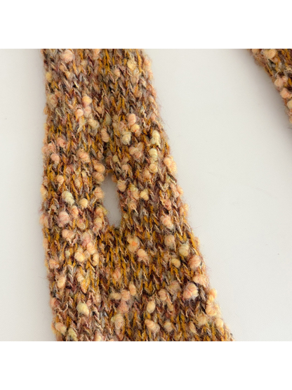 Close-up of the integrated pass-through slit in the textured scarf