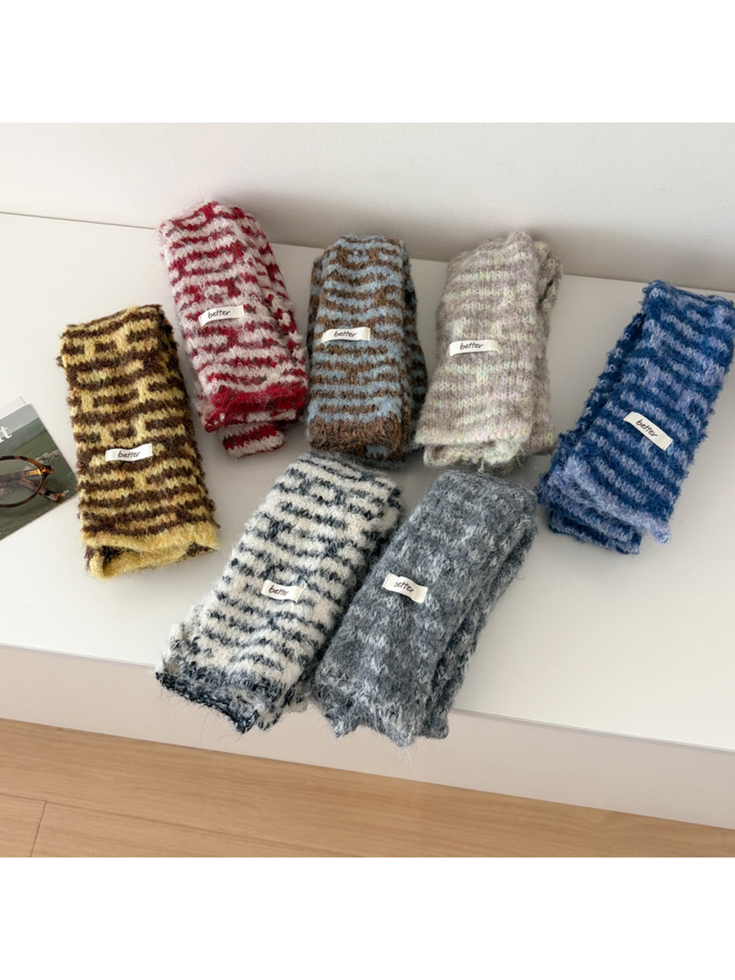 Seven fuzzy striped scarves in assorted colors displayed folded together