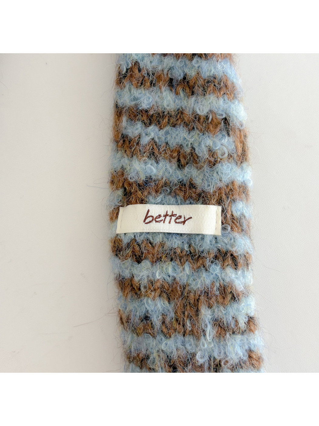 Close-up of the Light Blue striped scarf end and small fabric label