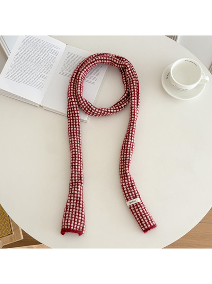 Red narrow check scarf arranged on a round table