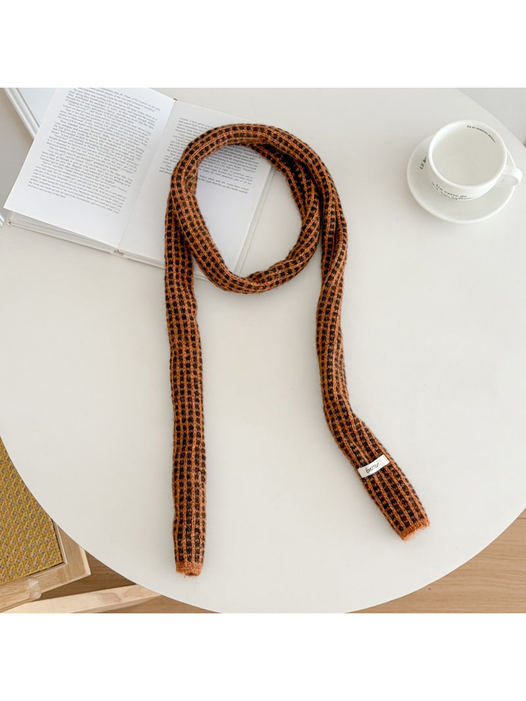 Orange narrow check scarf arranged on a round table