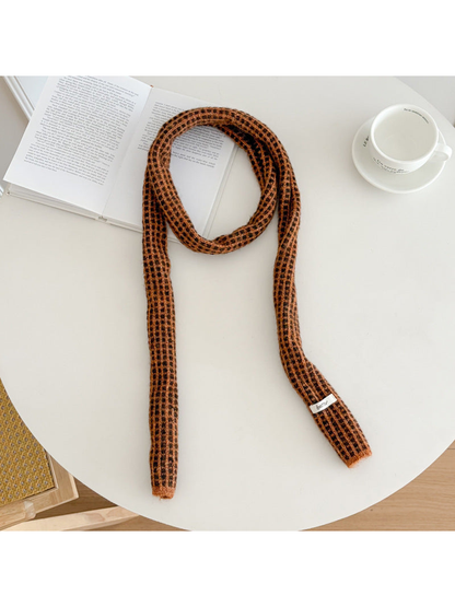 Orange narrow check scarf arranged on a round table