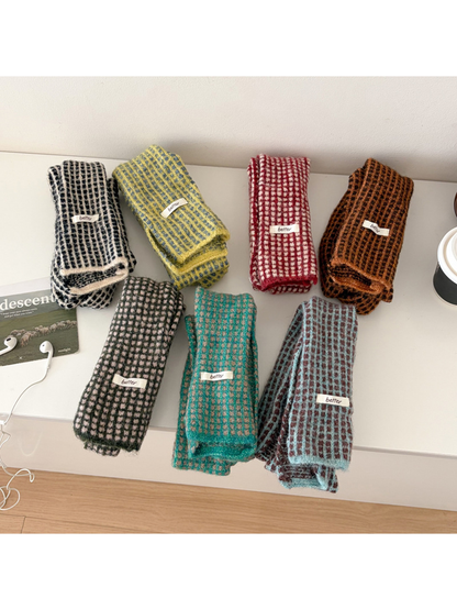 Seven folded check scarves displayed in assorted colors