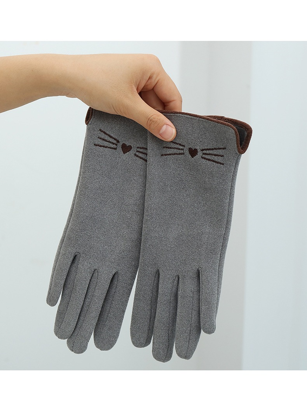 Gray cat-motif gloves held together against a pale background