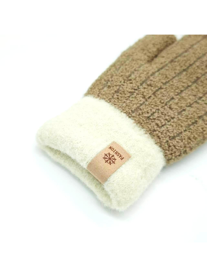 Close-up of a brown mitten's cream folded cuff and snowflake label