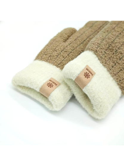 Close-up of two brown mitten cuffs with small snowflake labels