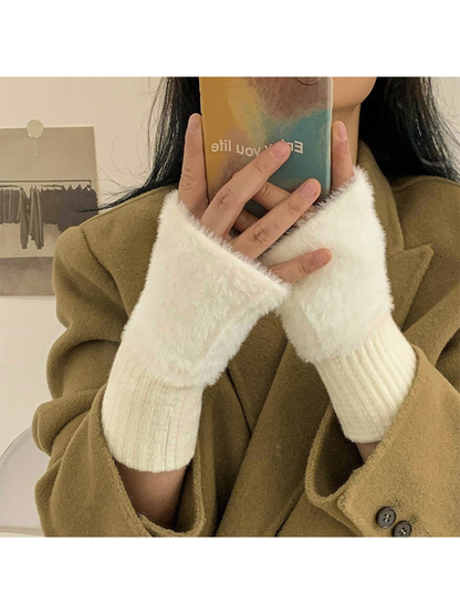 White fuzzy fingerless gloves worn with a camel coat