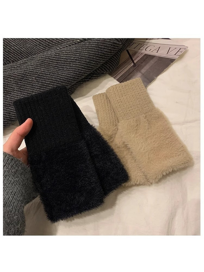 Black and khaki fuzzy fingerless gloves arranged in a flat lay