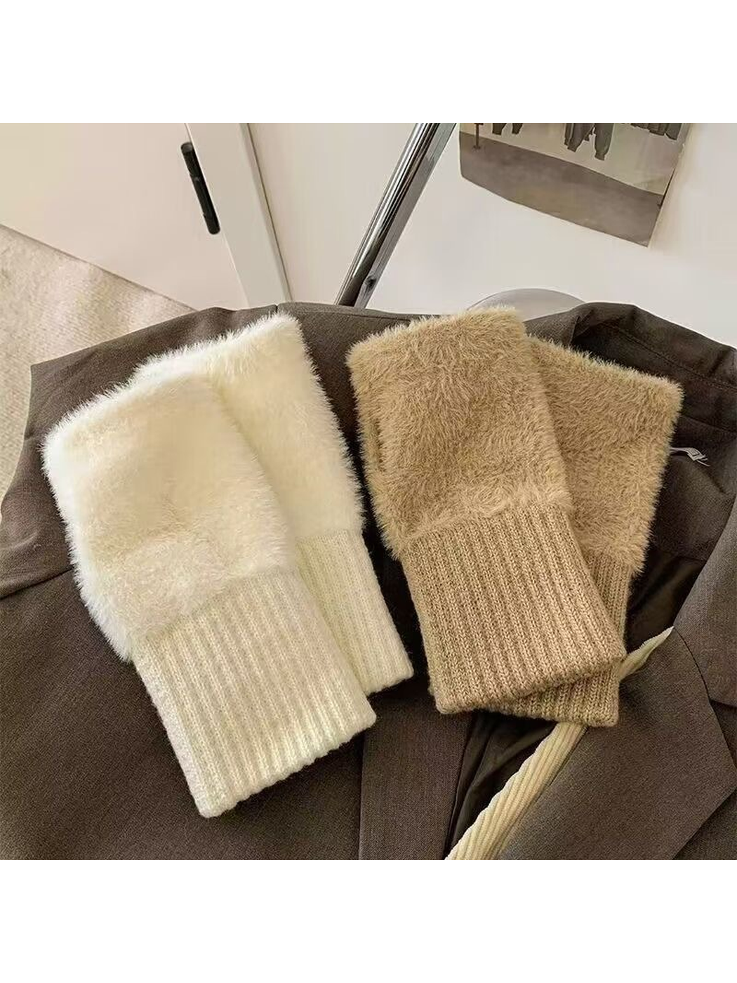 White and khaki fuzzy fingerless gloves displayed on a jacket