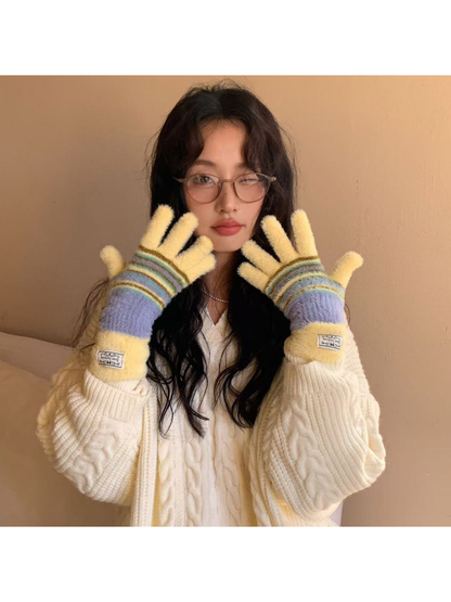 Multicolor fuzzy fingerless gloves worn with a cream cable-knit sweater