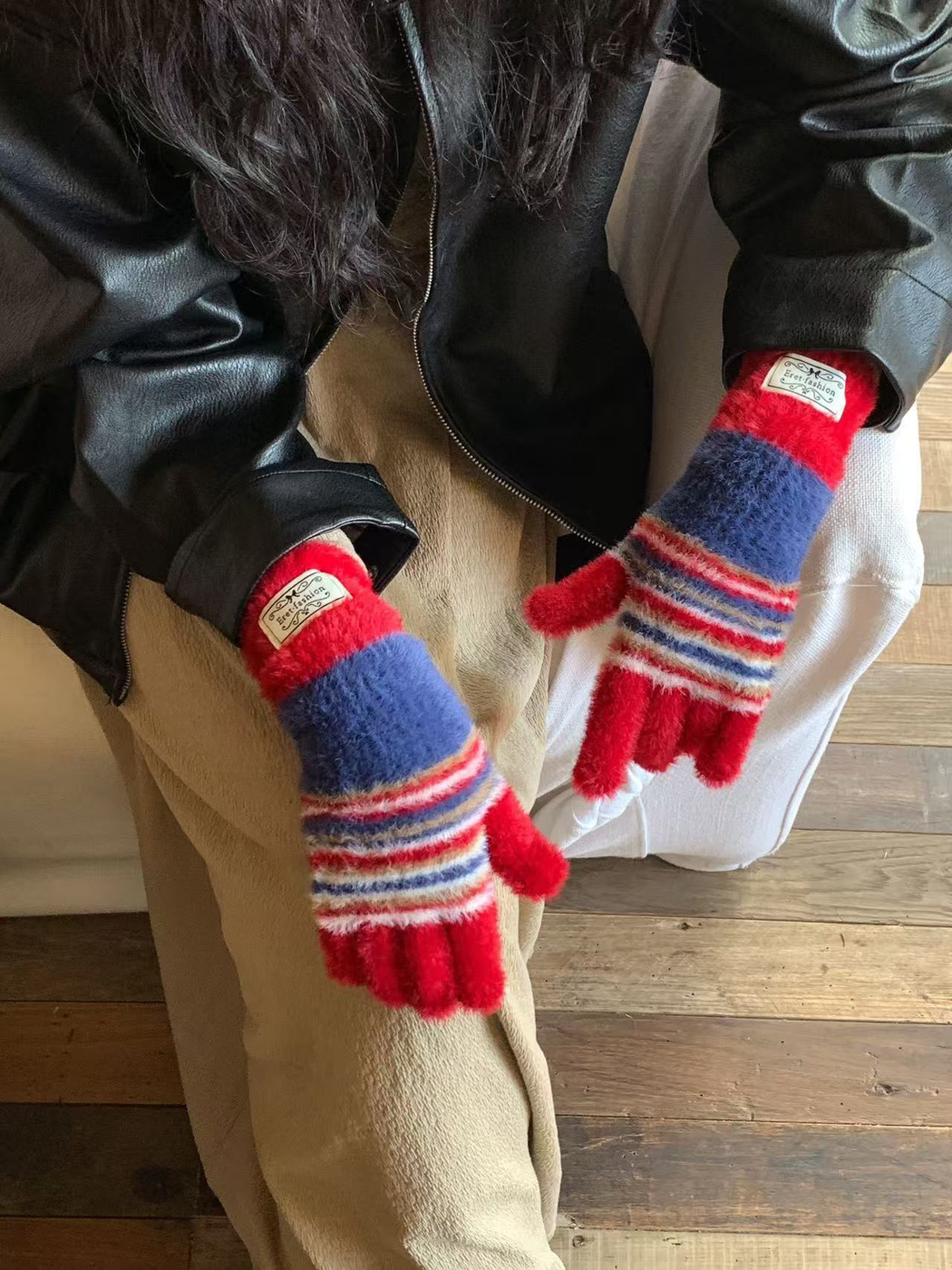 Close-up of Red fuzzy fingerless gloves with blue panels and striped palms