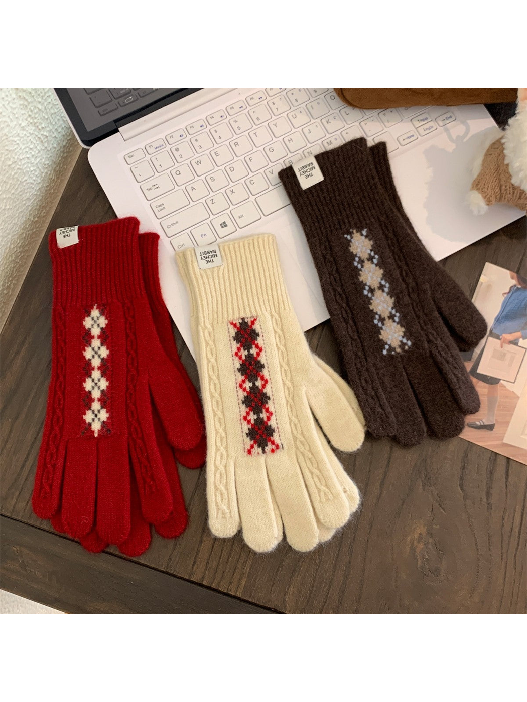 Red, ivory and brown patterned gloves arranged on a tabletop