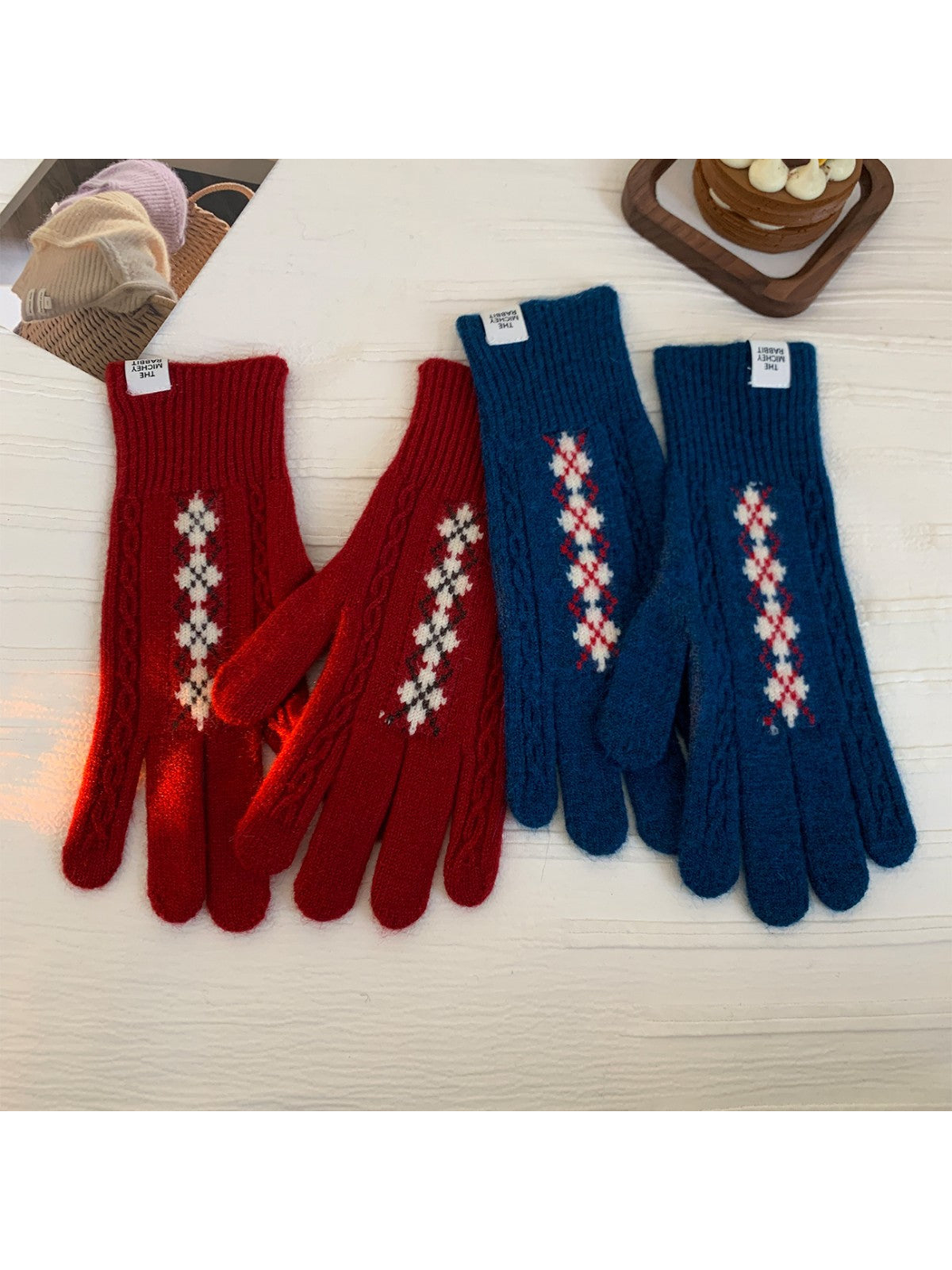 Red and teal blue patterned gloves displayed in pairs