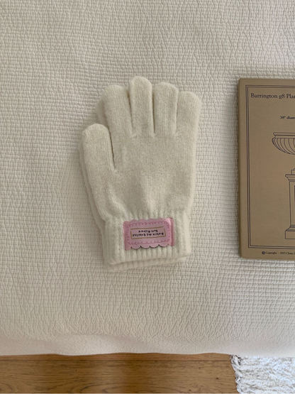 Ivory fuzzy knit gloves with ribbed cuffs and pink labels