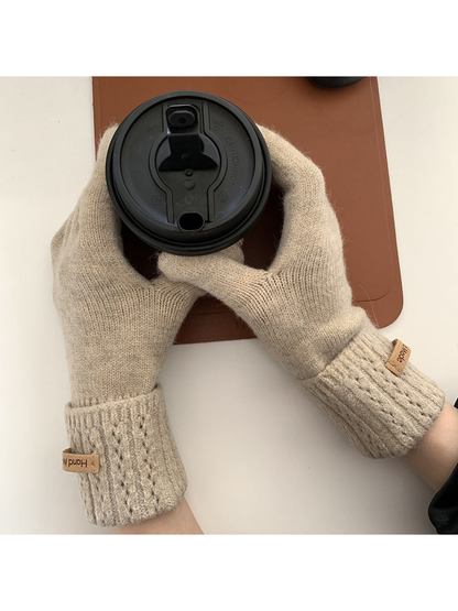 Beige gloves with extended ribbed cuffs holding a takeaway cup