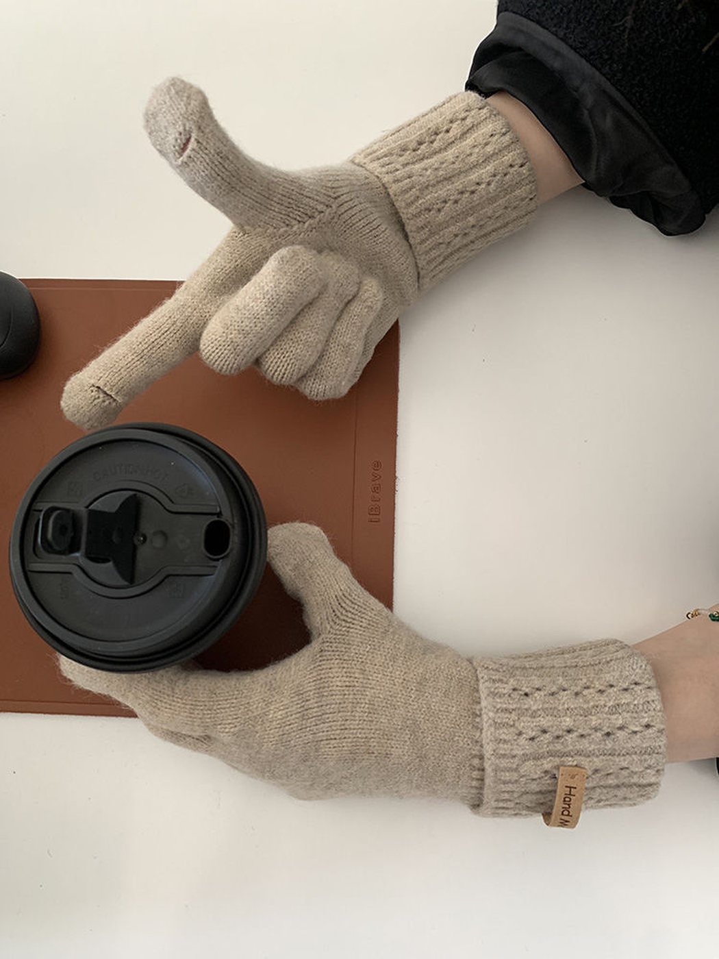 Close view of beige gloves with openings at the thumb and index fingertips