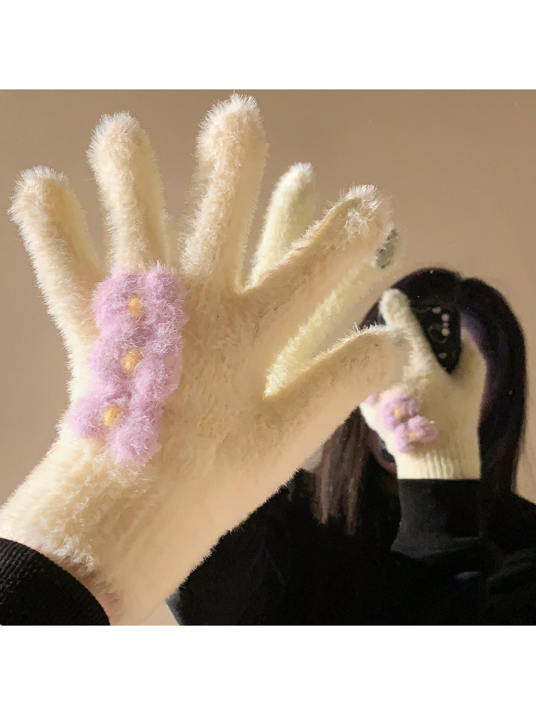 Yellow fuzzy gloves with purple flower appliqués worn in front of a mirror