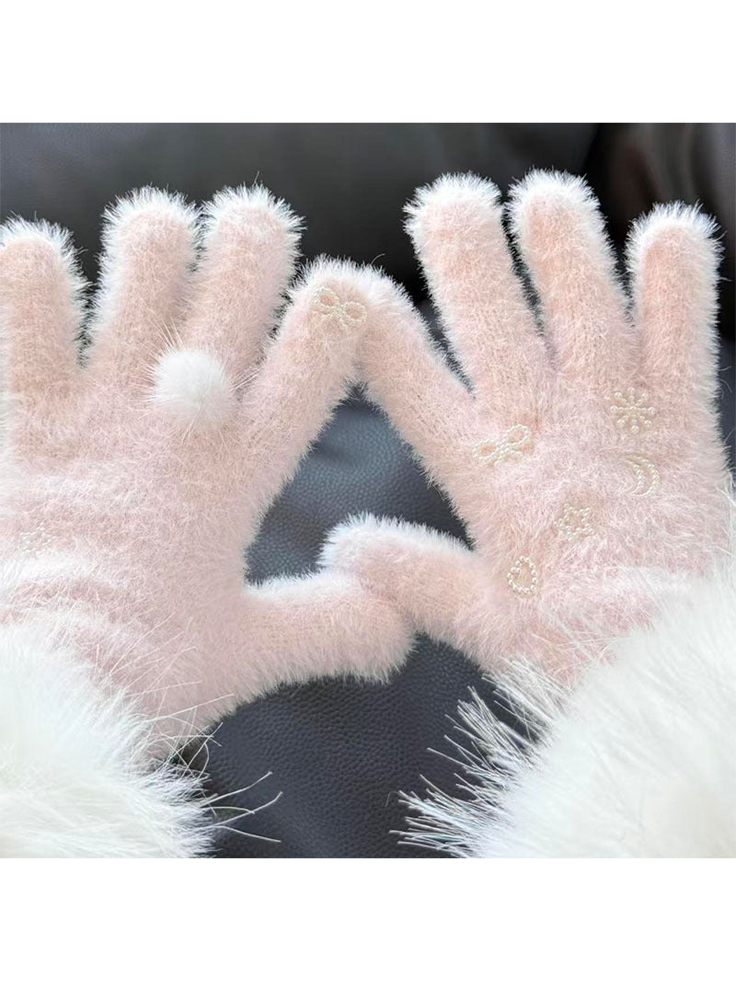 Close-up of Light Pink fuzzy gloves with a fluffy pom-pom and pearl-like motifs